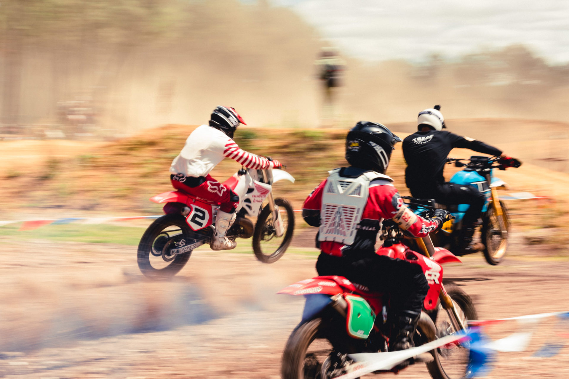 photo de trois motos cross en mouvement sur de la terre